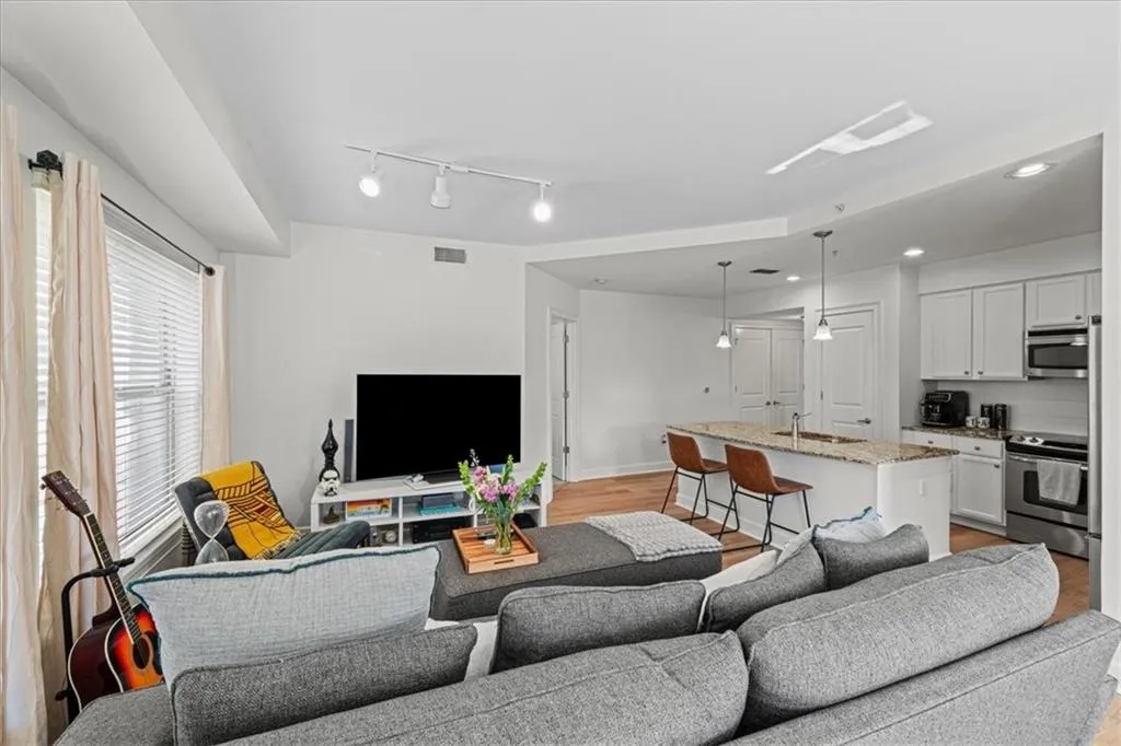 Living room with sink and light hardwood / wood-style flooring