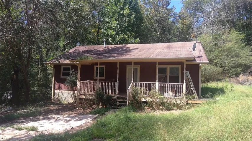 Red siding exterior with a covered front porch featuring wood railings