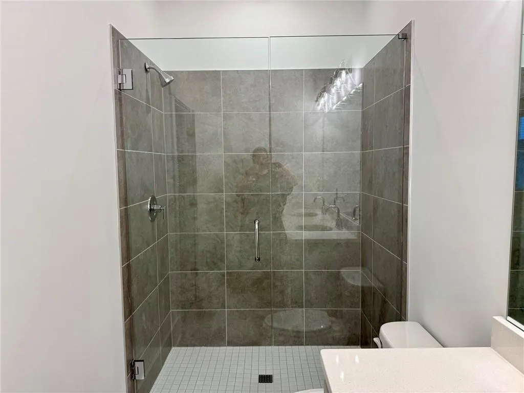 Tiled walk-in shower w/ frameless glass.  Example of design finishes planned for the home.