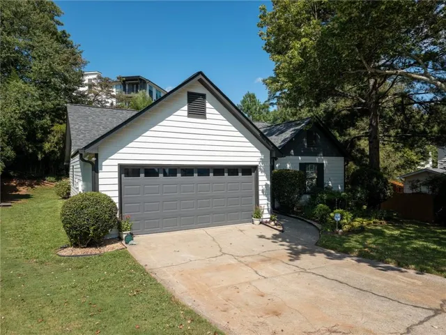 White horizontal siding exterior with a dark gray garage door