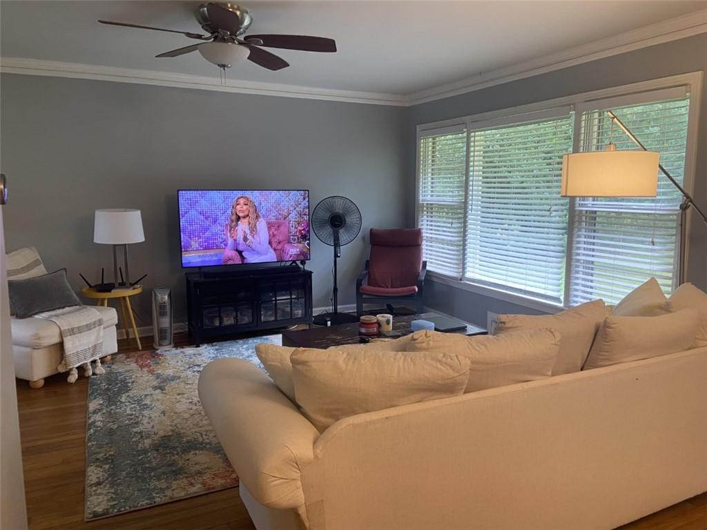 Living room with plenty of natural light, dark hardwood / wood-style floors, and ceiling fan
