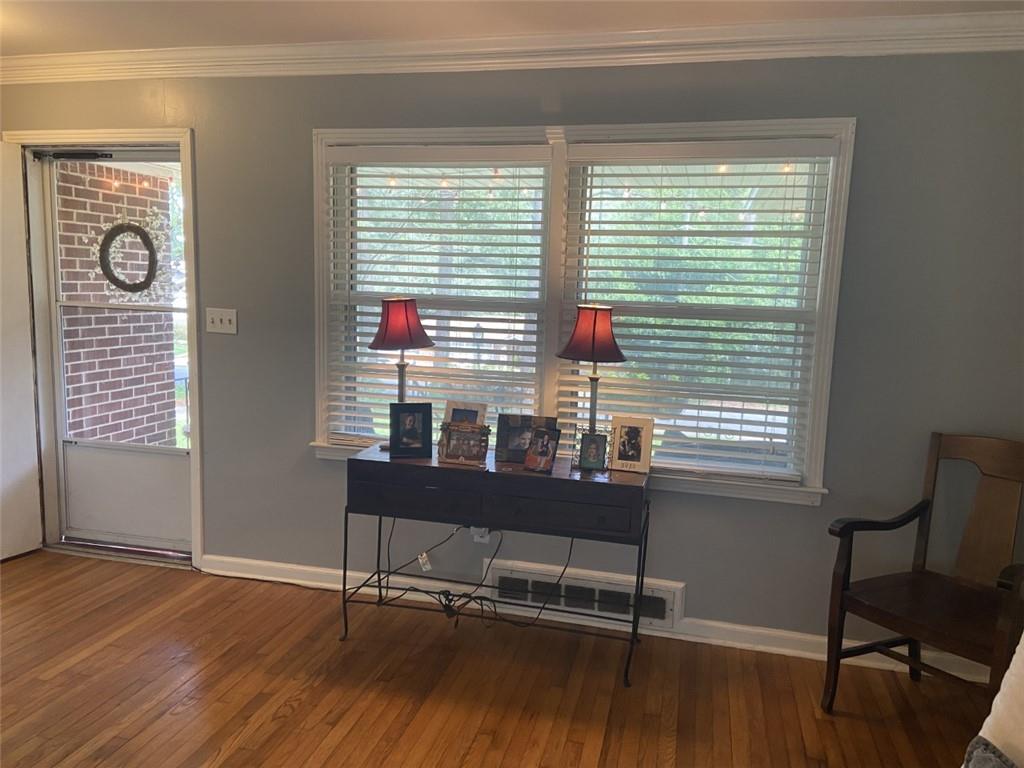 Entrance foyer with crown molding and dark wood-type flooring