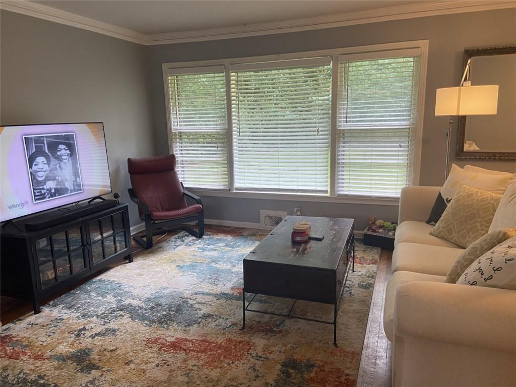 Living room featuring crown molding, a wealth of natural light, and dark hardwood / wood-style floors