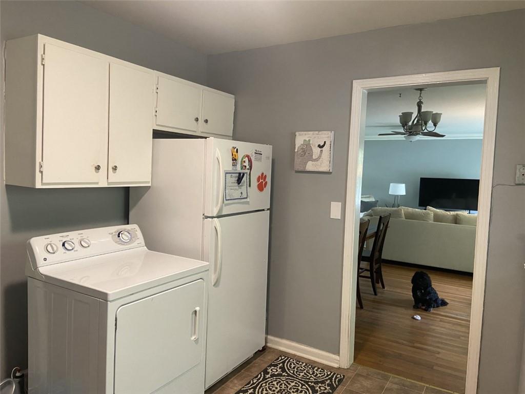 Washroom with washer and dryer, dark wood-type flooring, and ceiling fan