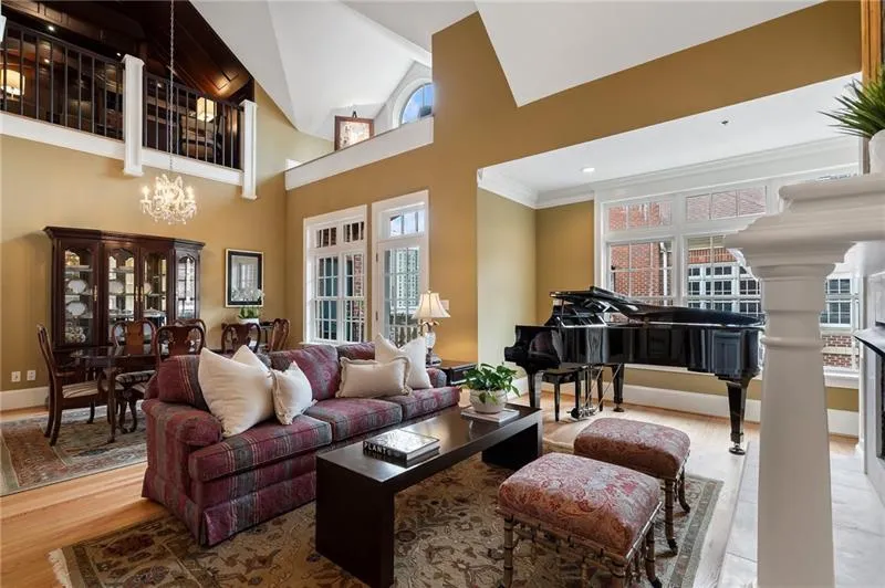 Living area with an inviting chandelier, a wealth of natural light, wood finished floors, and crown molding