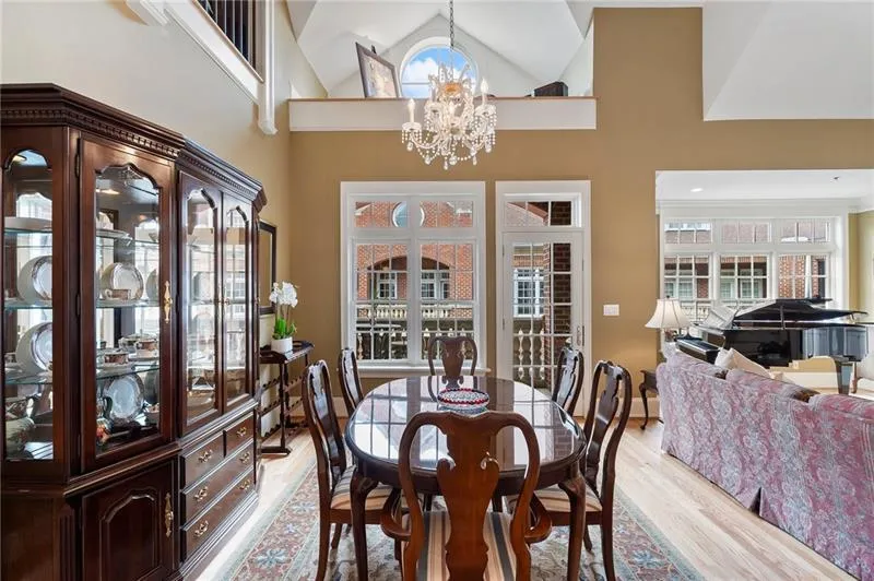 Dining space featuring high vaulted ceiling, a chandelier, and light wood-style floors