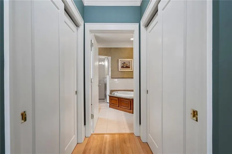 Corridor featuring ornamental molding and light tile patterned flooring
