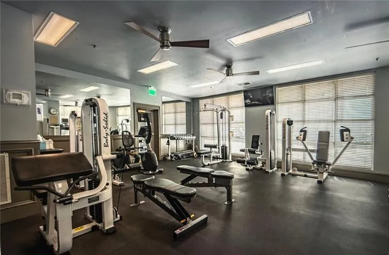 Gym with a wealth of natural light and a ceiling fan