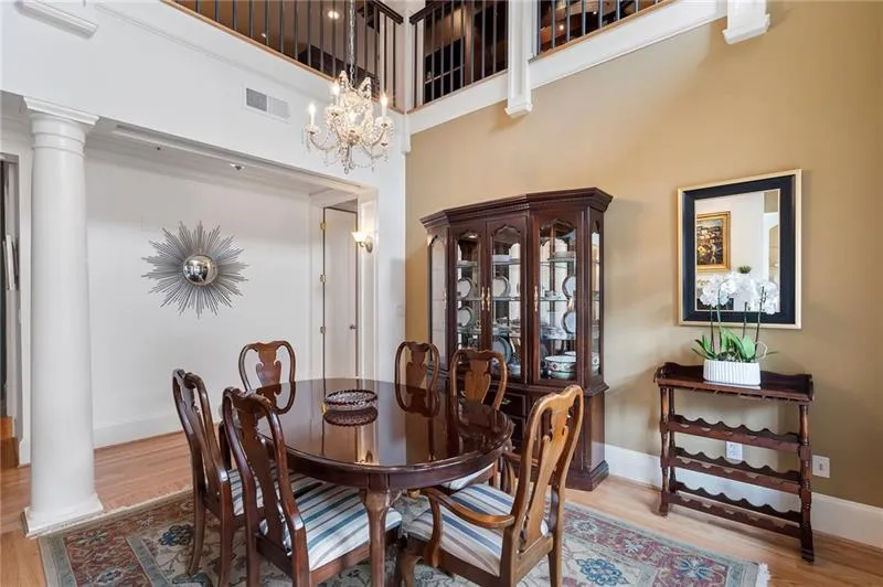 Dining room with ornate columns, visible vents, wood finished floors, and baseboards