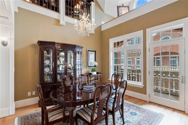 Dining area featuring wood finished floors, a chandelier, a towering ceiling, and baseboards