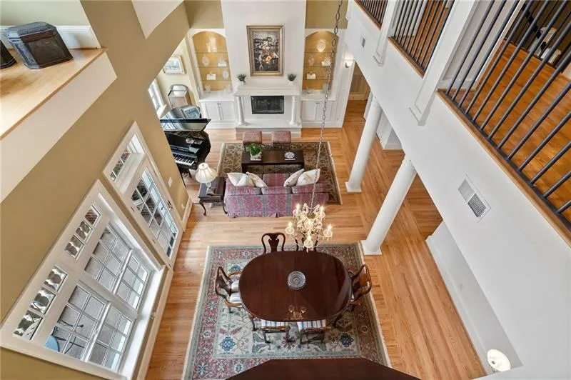 Living area with a high ceiling, visible vents, and a healthy amount of sunlight