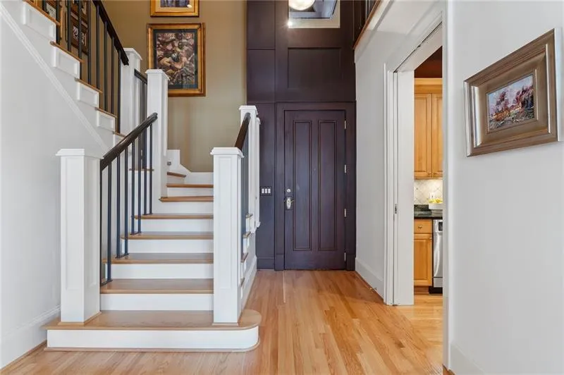 Entrance foyer with light wood finished floors, stairway, and baseboards