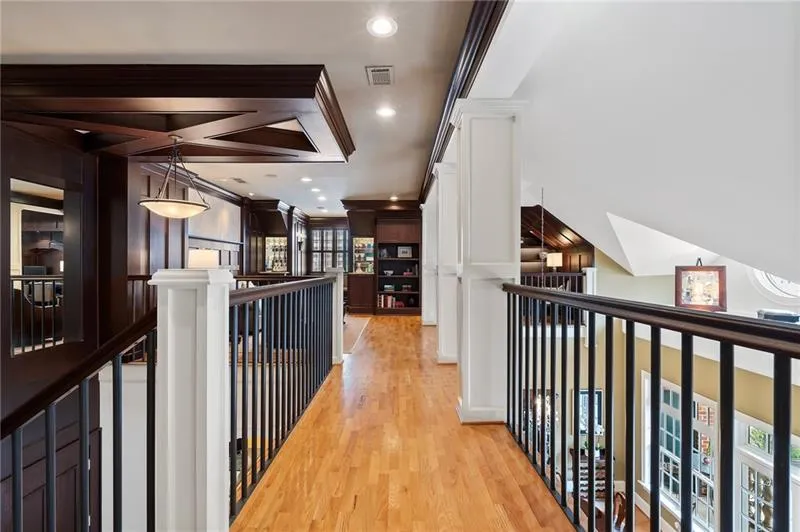 Hallway with light wood-style flooring, an upstairs landing, visible vents, recessed lighting, and ornamental molding