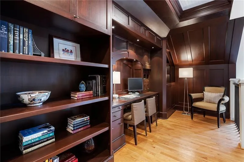 Office area featuring crown molding, light wood-style flooring, and a decorative wall