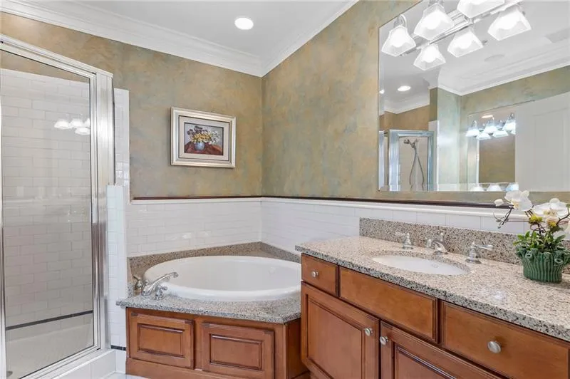 Bathroom with ornamental molding, a bath, vanity, visible vents, and a stall shower
