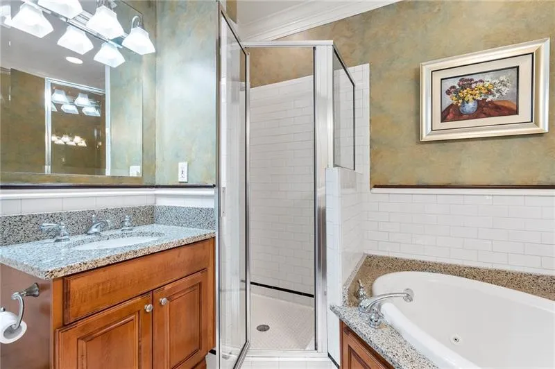 Full bathroom with a tub with jets, vanity, a stall shower, and tile walls