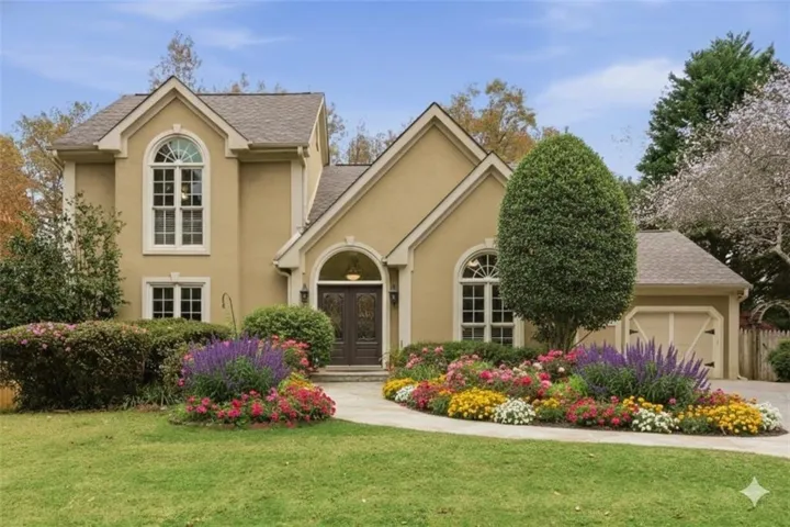 Stucco exterior featuring arched windows and a two-car garage