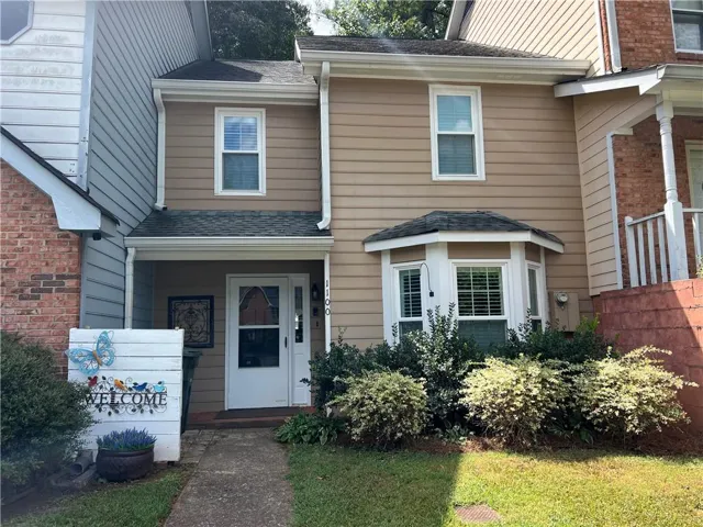 Siding exterior with multiple windows, covered front entrance, and a bay window