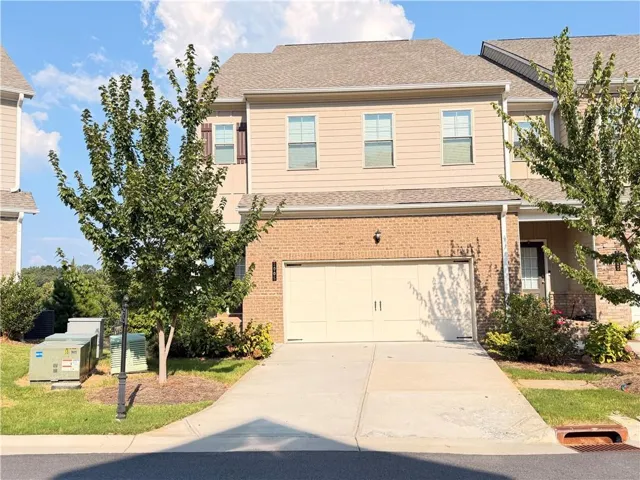 Brick and siding exterior, two-car garage, concrete driveway, mature landscaping, covered entry
