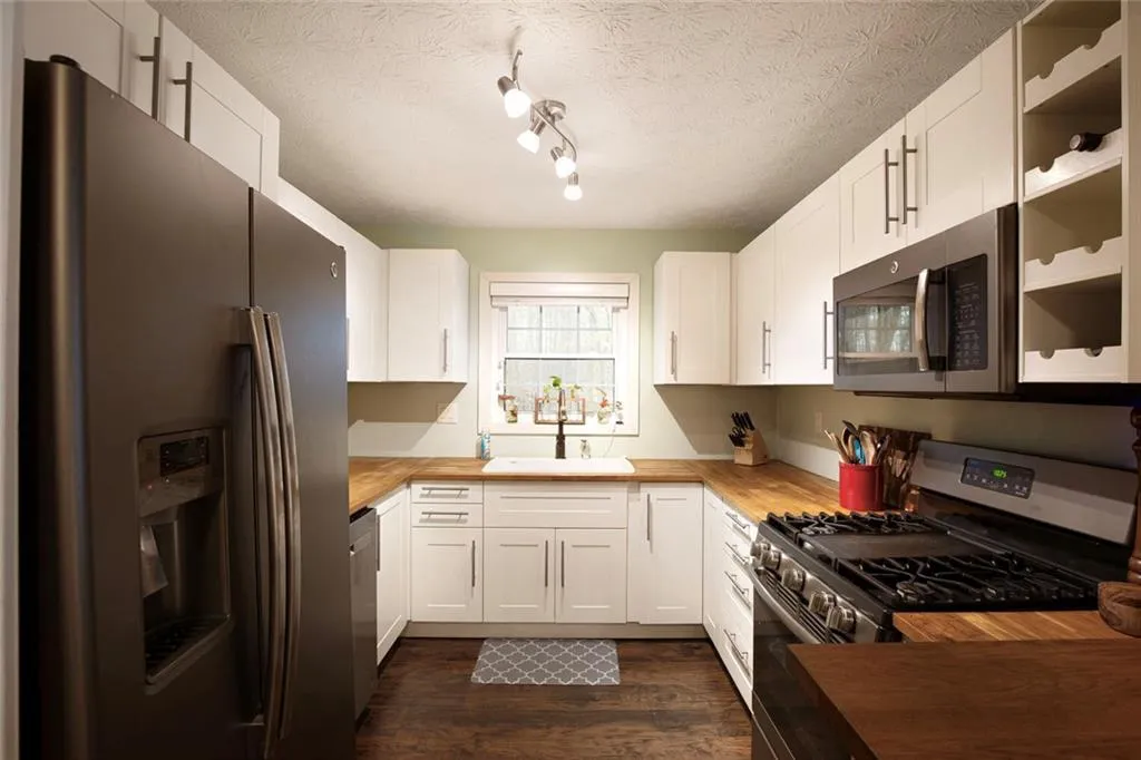 Butcher block couners and white cabinets. Fridge r