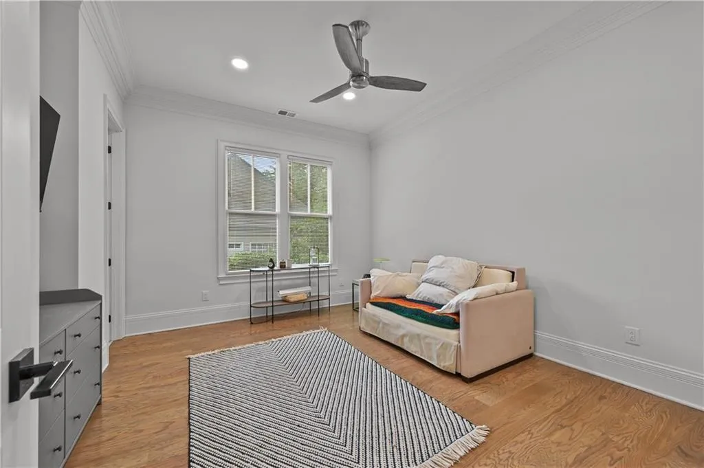 Living area featuring light wood-type flooring, crown molding, ceiling fan, and recessed lighting