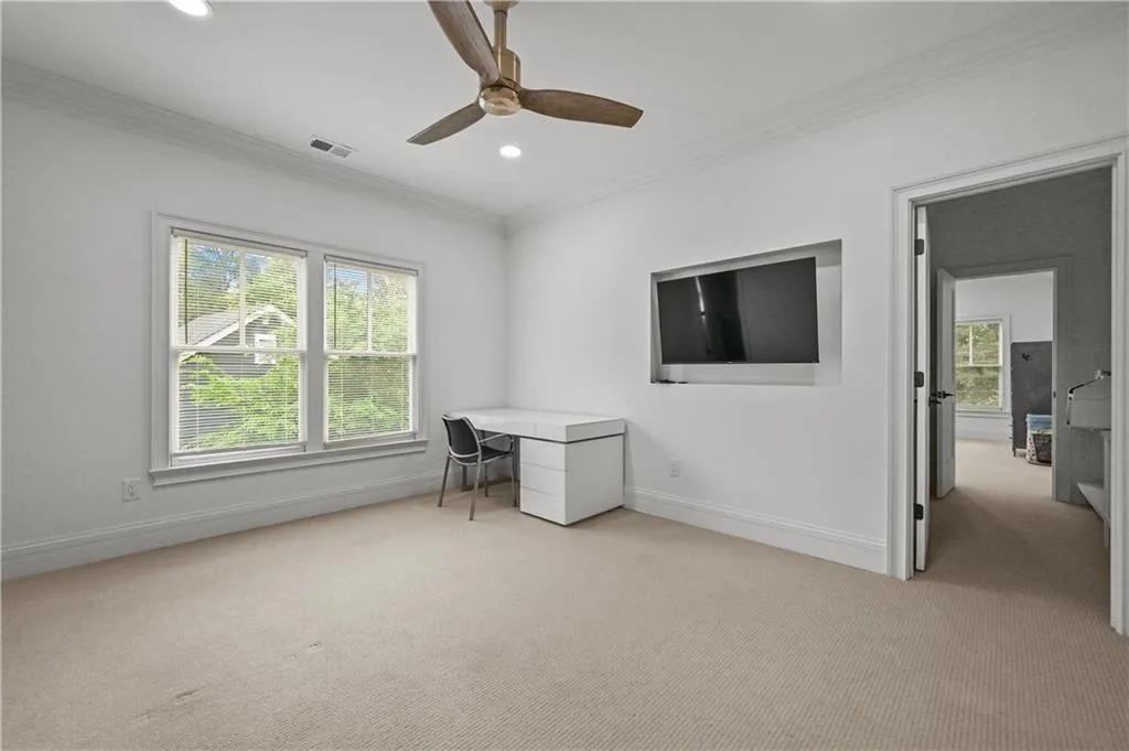 Unfurnished office with crown molding, light colored carpet, healthy amount of natural light, a ceiling fan, and recessed lighting