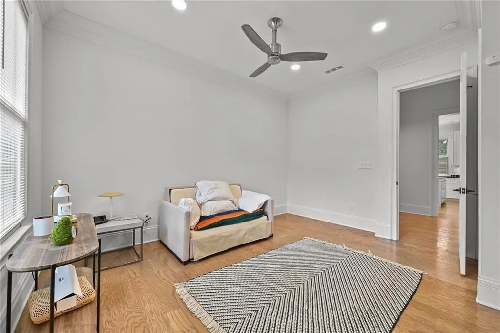 Living area with light wood-type flooring, crown molding, recessed lighting, and a ceiling fan