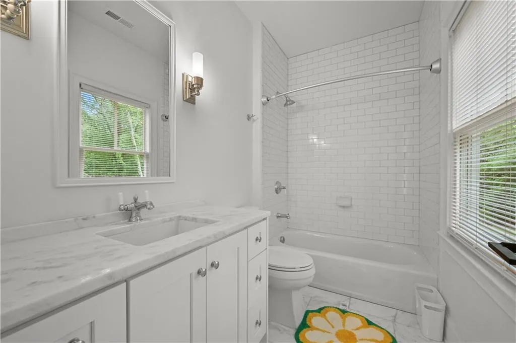 Full bath featuring vanity, healthy amount of natural light, and bathing tub / shower combination