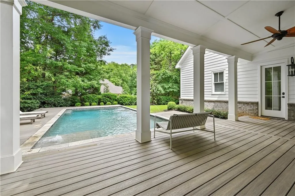 Swimming pool featuring a wooden deck and a ceiling fan