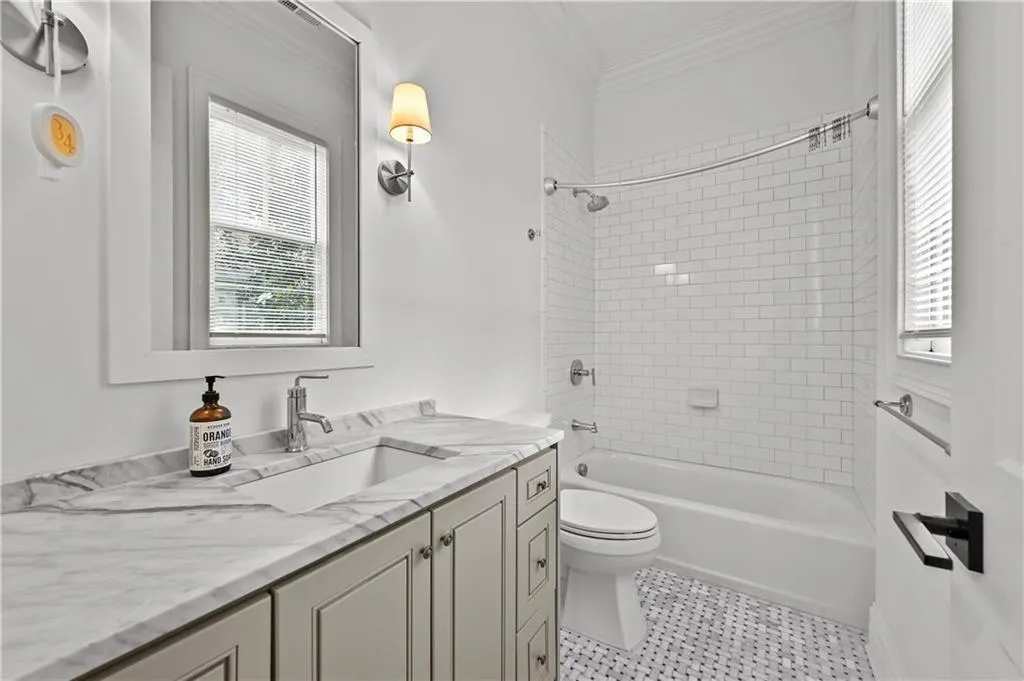 Full bathroom featuring vanity, shower / tub combination, ornamental molding, healthy amount of natural light, and tile patterned floors
