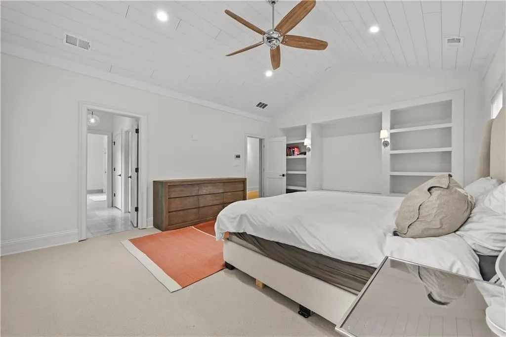 Bedroom featuring lofted ceiling, wooden ceiling, carpet, a ceiling fan, and crown molding