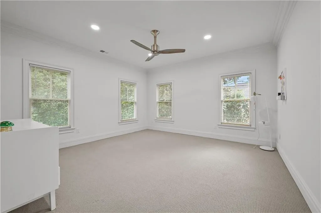 Empty room with crown molding, light carpet, recessed lighting, and ceiling fan