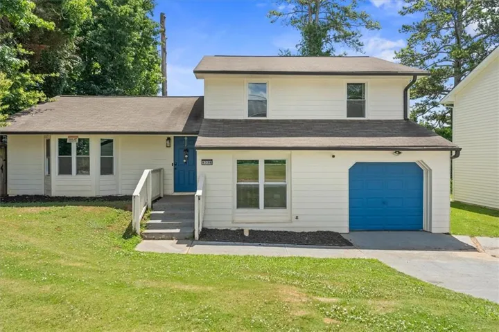 Charming two-story home with a bright, open facade featuring crisp white siding and distinctive blue accents