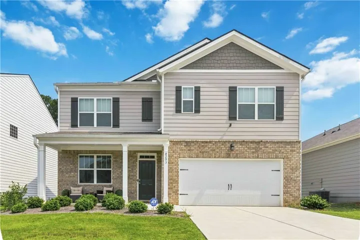 Two-story property featuring a covered front porch, brick and siding exterior, front-facing attached garage, and a concrete driveway