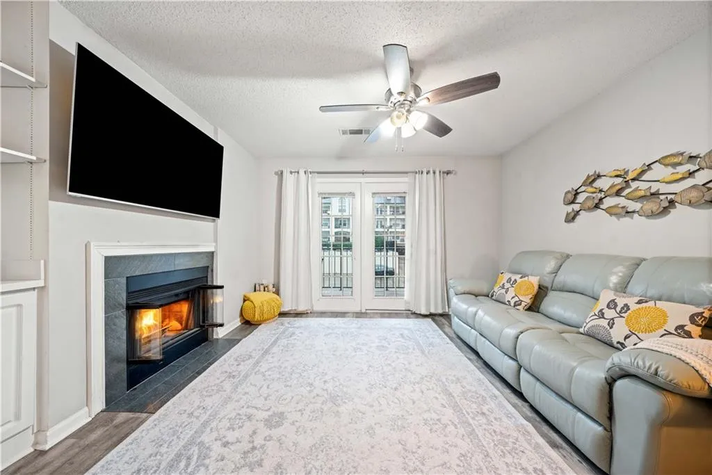 Living room featuring ceiling fan, dark hardwood / wood-style floors, and a textured ceiling
