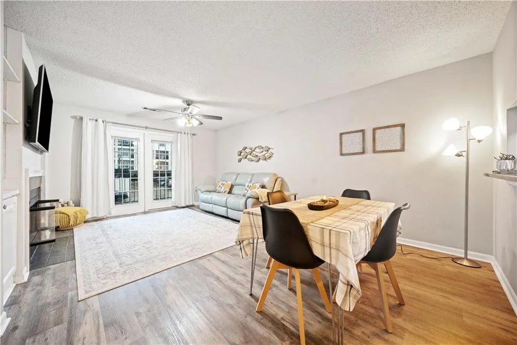 Dining room featuring ceiling fan, hardwood / wood-style floors, and a textured ceiling