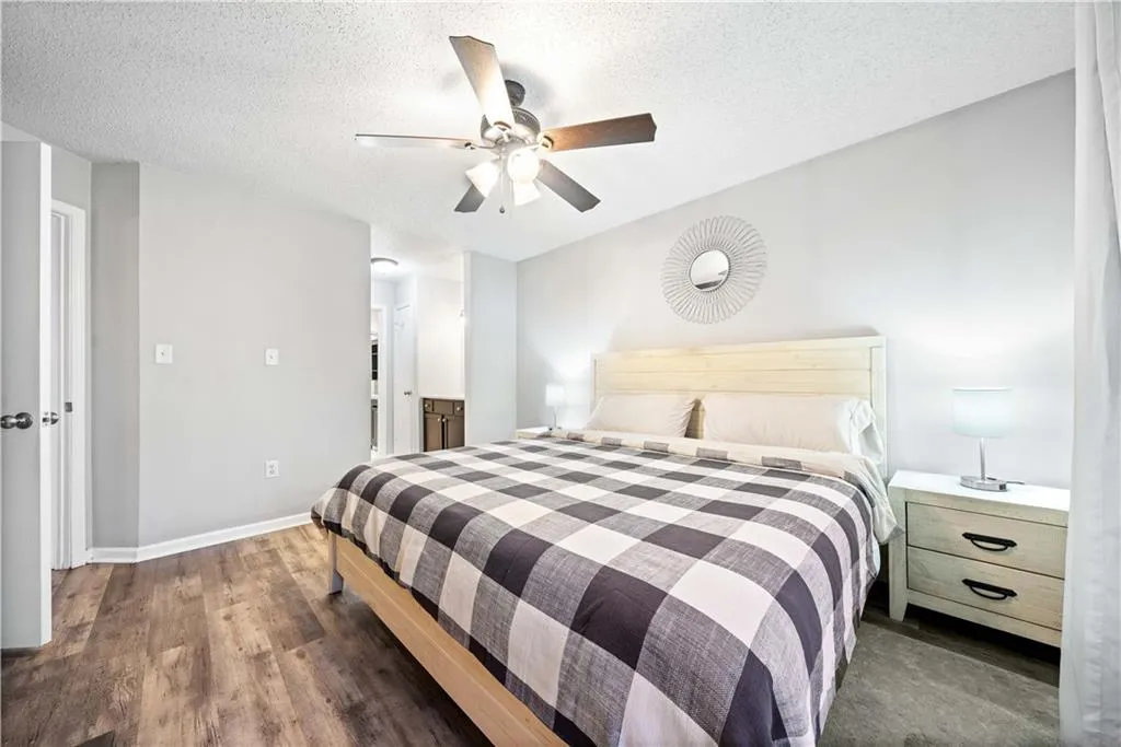 Bedroom featuring ceiling fan, dark hardwood / wood-style flooring, and a textured ceiling