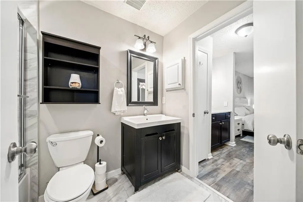 Bathroom with vanity, a textured ceiling, and toilet