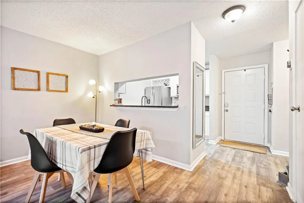 Dining area with light hardwood / wood-style floors and a textured ceiling