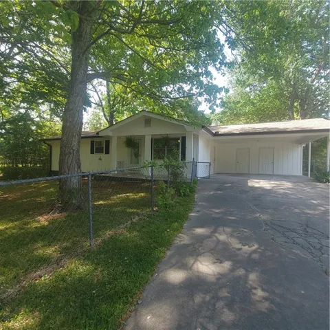 Single-story residence featuring a covered front porch, white siding, and dark shutters