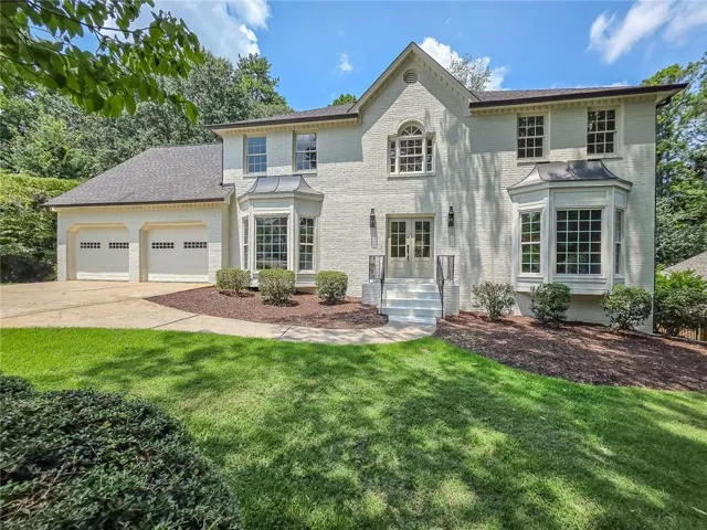 Painted brick exterior featuring a multi-gabled roofline and a double-door entry with steps