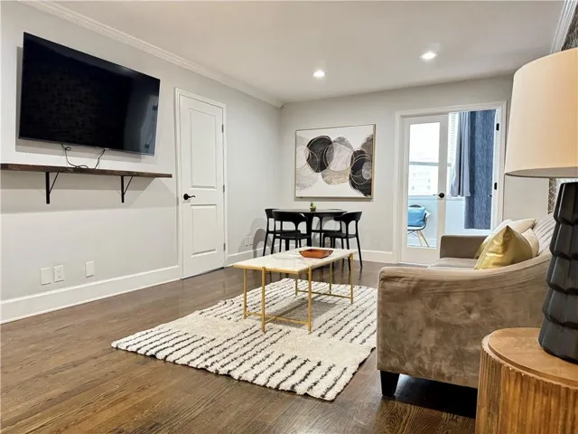 Dark wood-finish flooring, white trim, and light gray wall paint