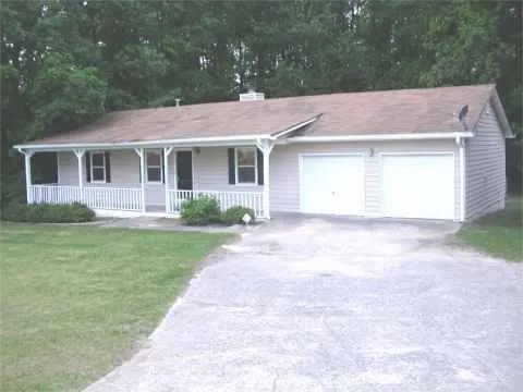 Ranch-style exterior with a covered front porch, white railings, and a two-car attached garage