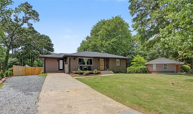 Single-story residence featuring a brick and horizontal siding exterior, a dark shingle roof, and a concrete driveway