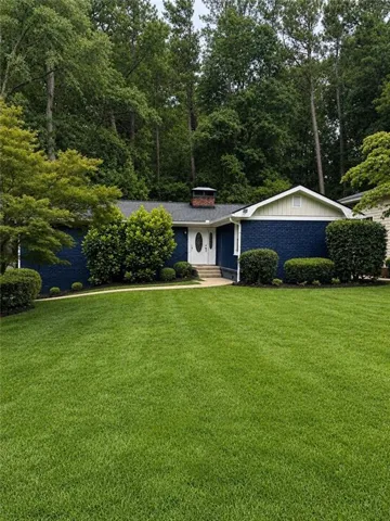 Ranch-style residence featuring a prominent front lawn with a curved walkway