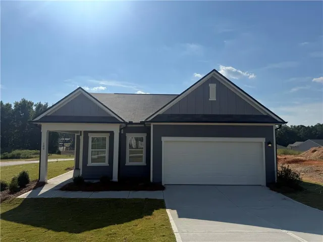 Single-story residence featuring a covered entry porch, attached two-car garage, and a concrete driveway