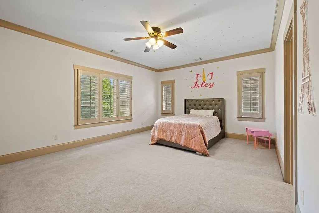 Bedroom with light carpet, crown molding, and ceiling fan