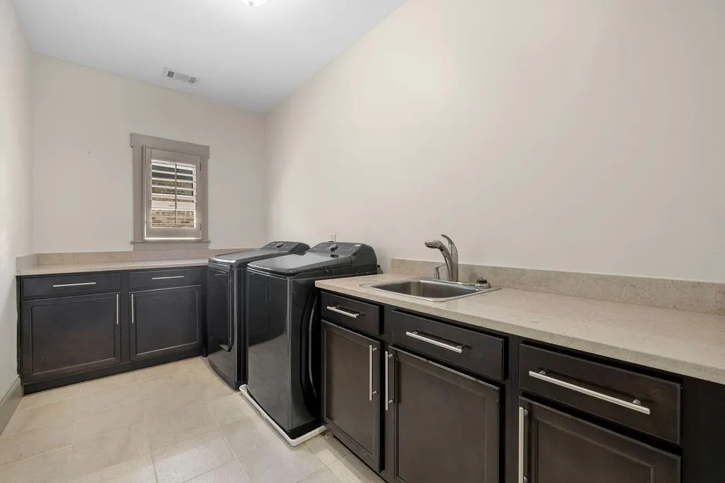 Laundry room with cabinets, sink, light tile patterned floors, and independent washer and dryer