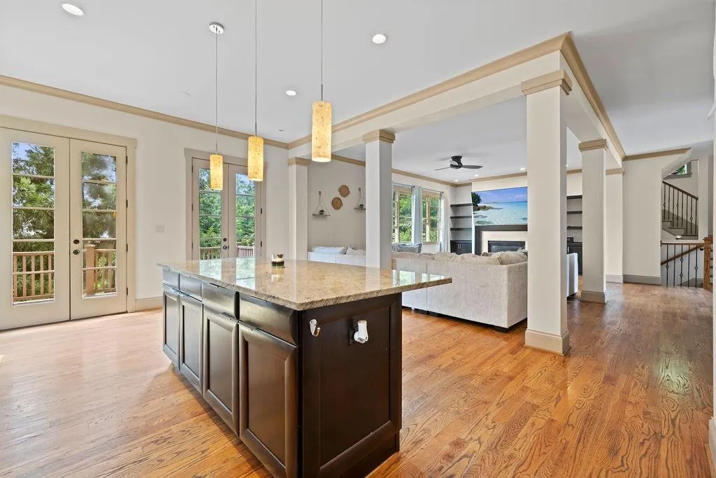 Kitchen with hanging light fixtures, light wood-type flooring, a healthy amount of sunlight, ceiling fan, and french doors