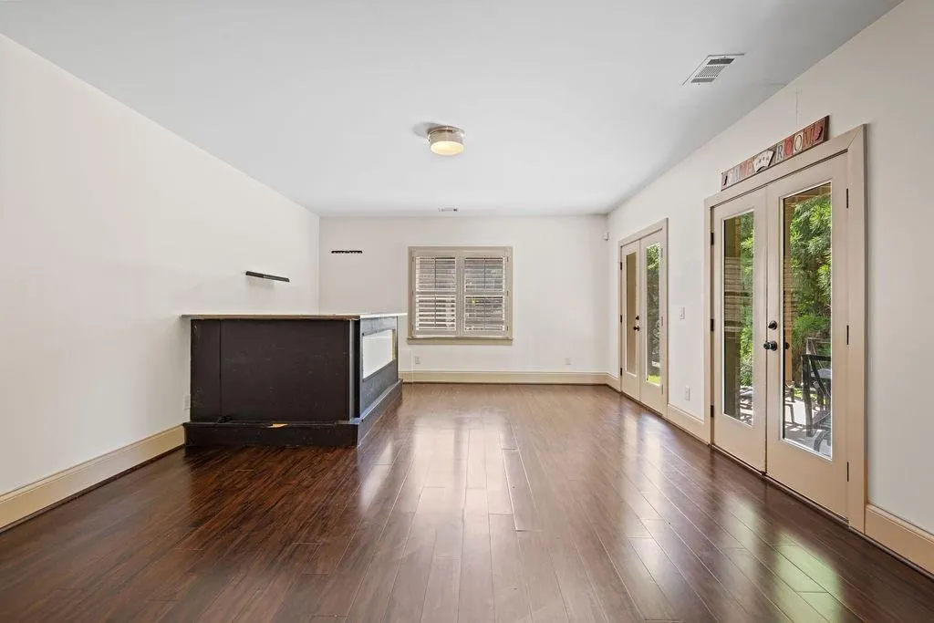 Unfurnished living room with french doors and dark hardwood / wood-style flooring